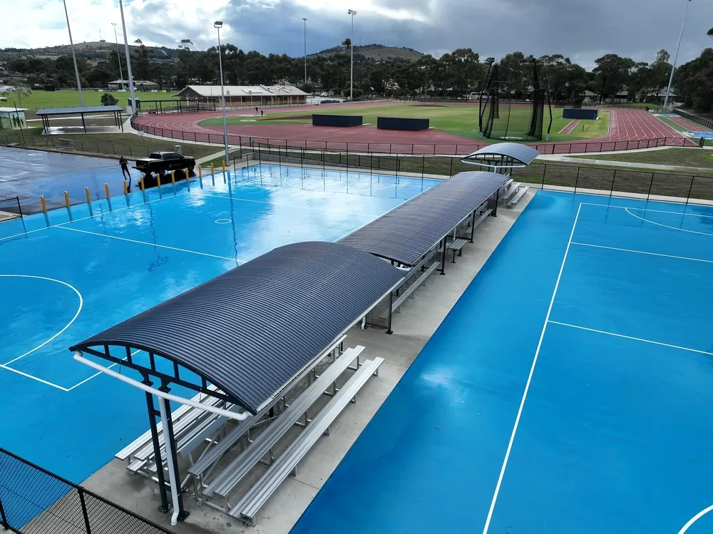 Drone shot of a curved shelter roof over the netball courts